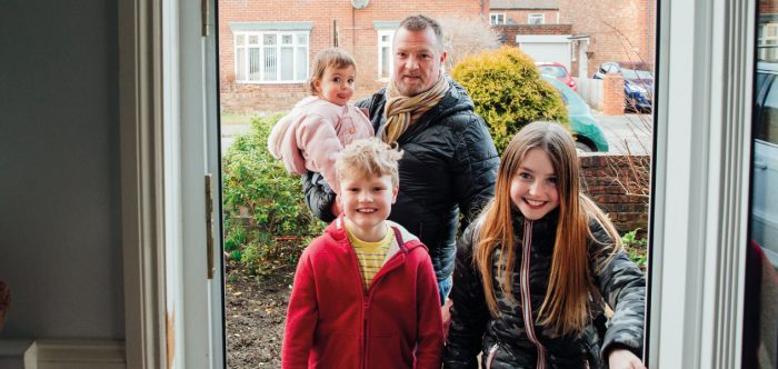 A family walking in the front door of their house