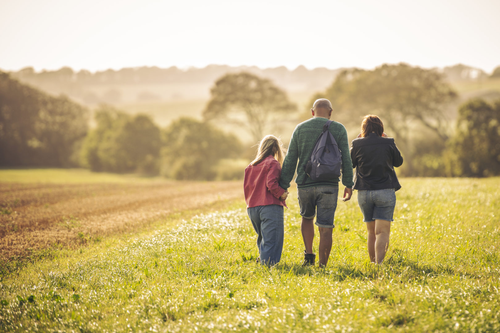 Family walking in a field on a sunny day