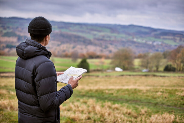 Man holding a map and looking into distance
